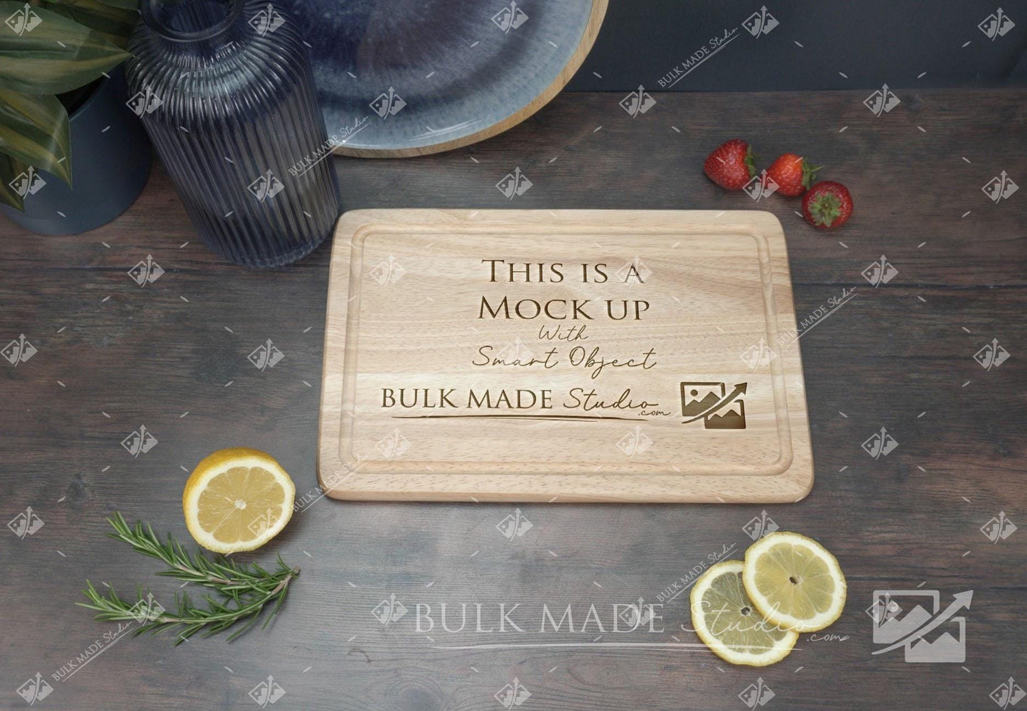 a wooden cutting board with a message carved into it, surrounded by various fruits and a potted plant on a wooden surface.