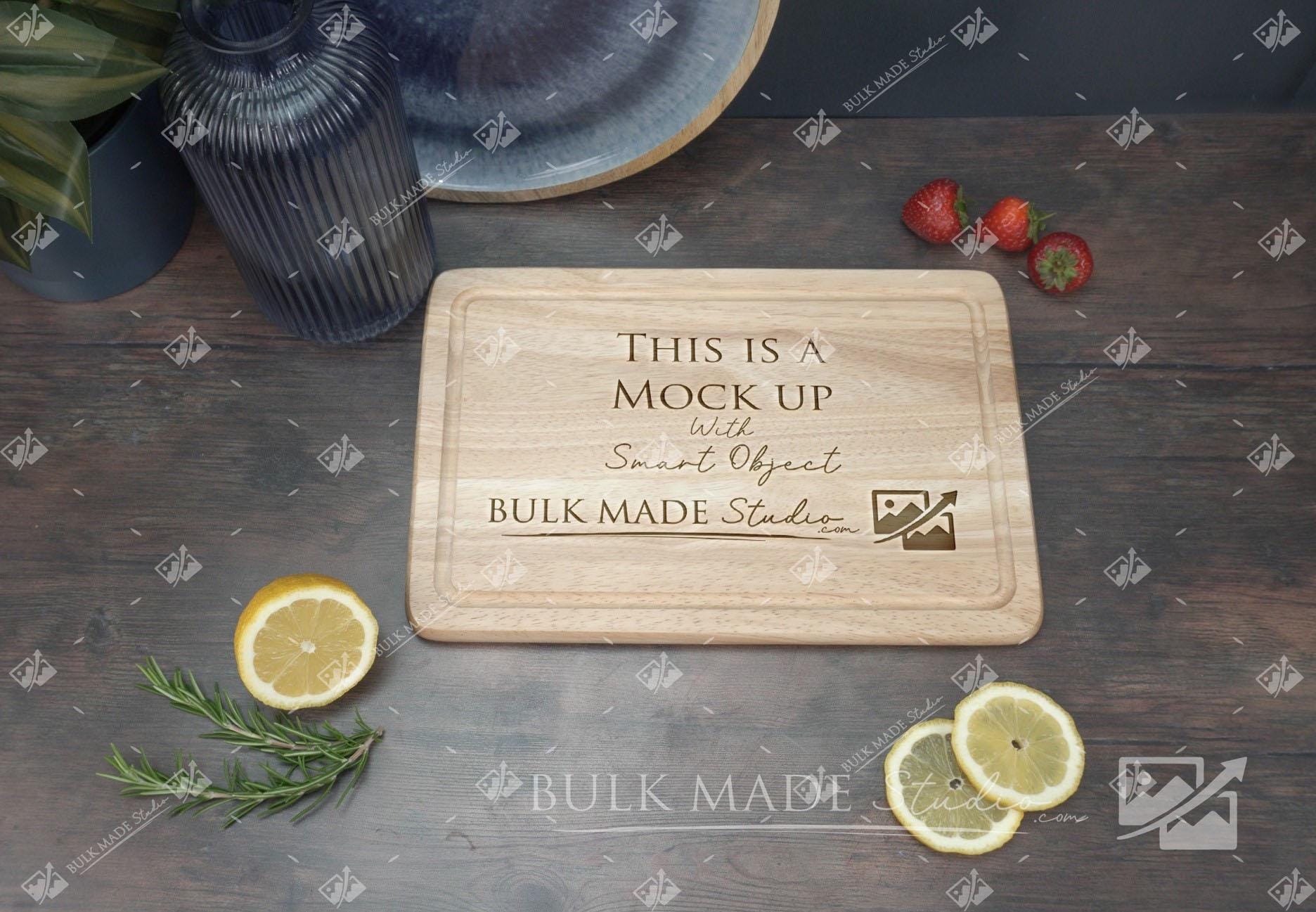 a wooden cutting board with a message carved into it, surrounded by various fruits and a potted plant on a wooden surface.